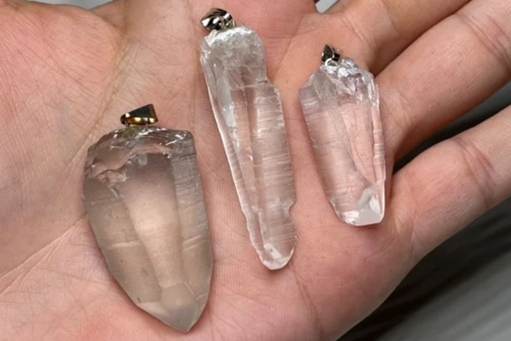 Lemurian Seed Crystals pendants on a persons hand. Source: Etsy | EarthsMineralsInc