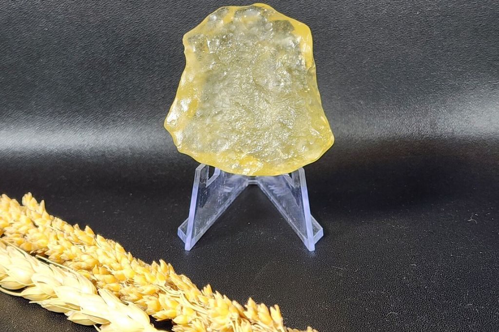 A libyan desert glass crystal on a plastic pedestal stand. Source: Etsy | Earth Craft