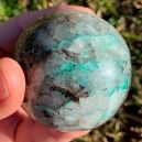 A person holding a Quantum Quattro sphere crystal. Source: Etsy | EarthRockElements