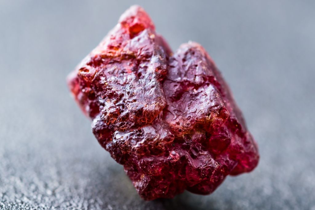 A raw spinel crystal on a blackish background