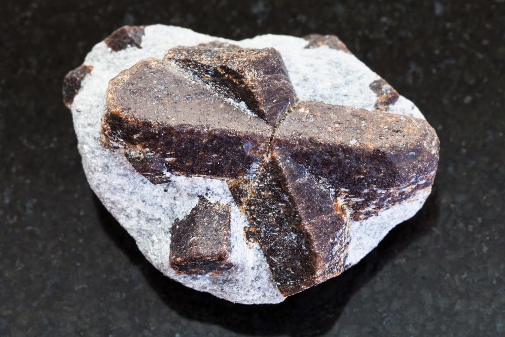 A Staurolite crystal on a black granite