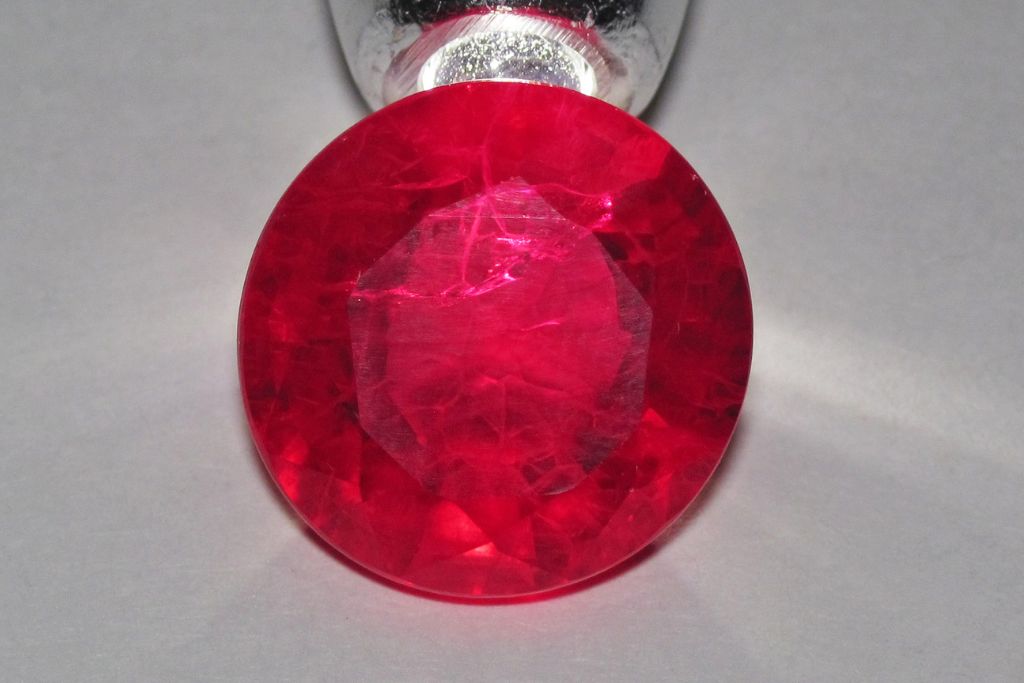 Round shaped Synthetic Ruby on a gray background