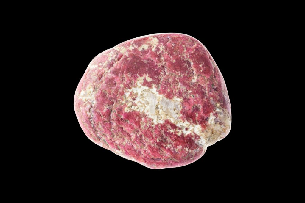 A Thulite crystal on a black background