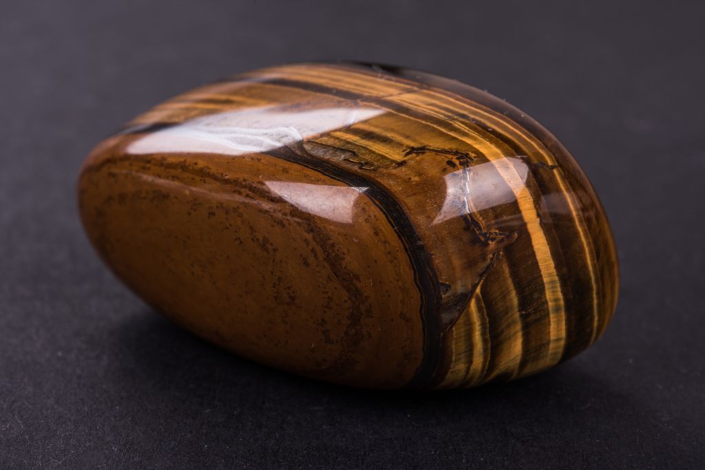 A polished Tiger's eye crystal on a dark background