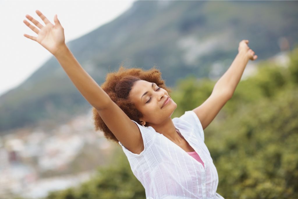 a woman spreading her arms in the sky while smiling