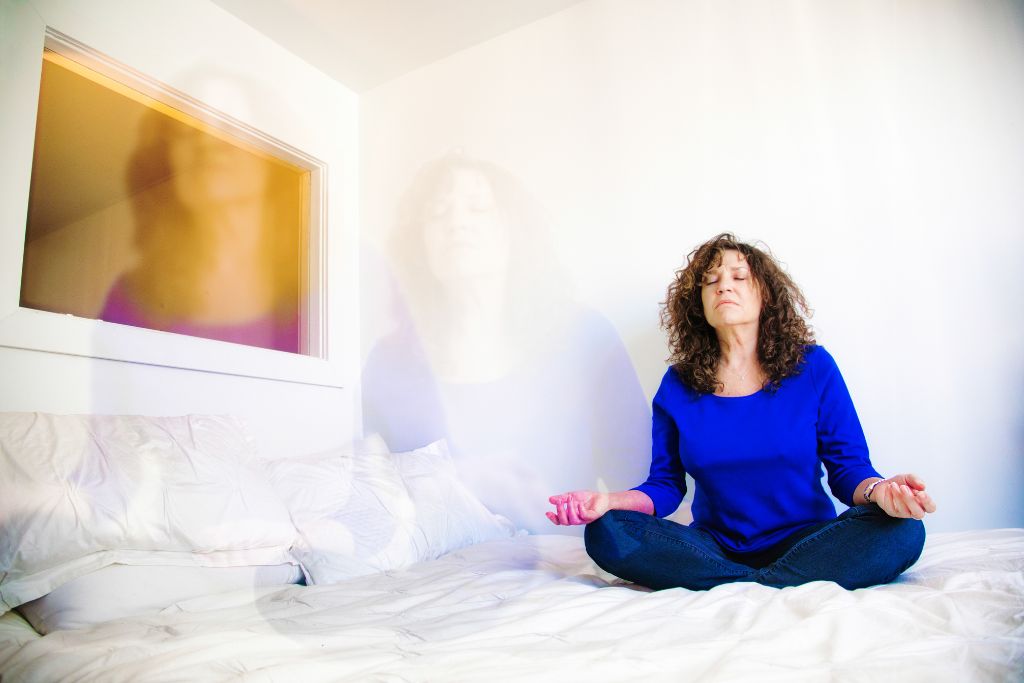 Female practicing astral projection on her bed