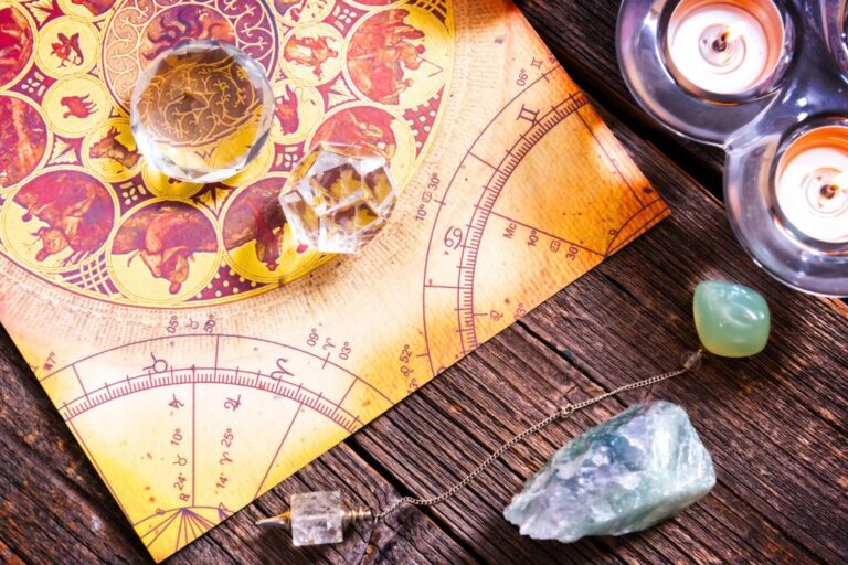 astrology map, crystals, and candles arranged on the table