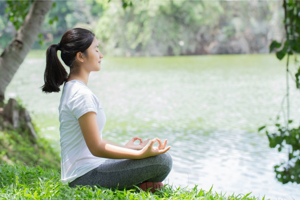 female meditating by the lake