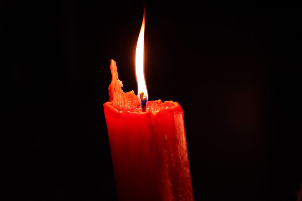 a red lit candle in black background