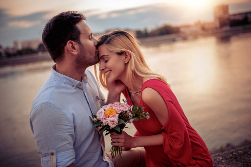 man kissing woman's forehead