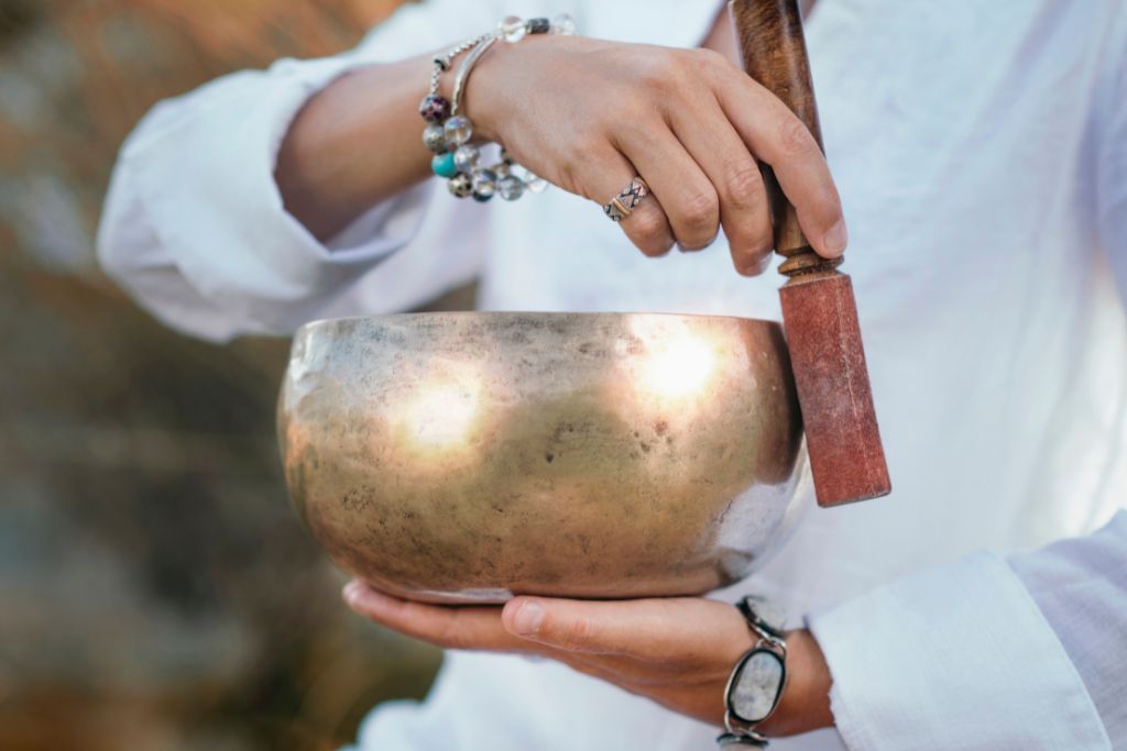 a person performing cleansing using a singing bowl