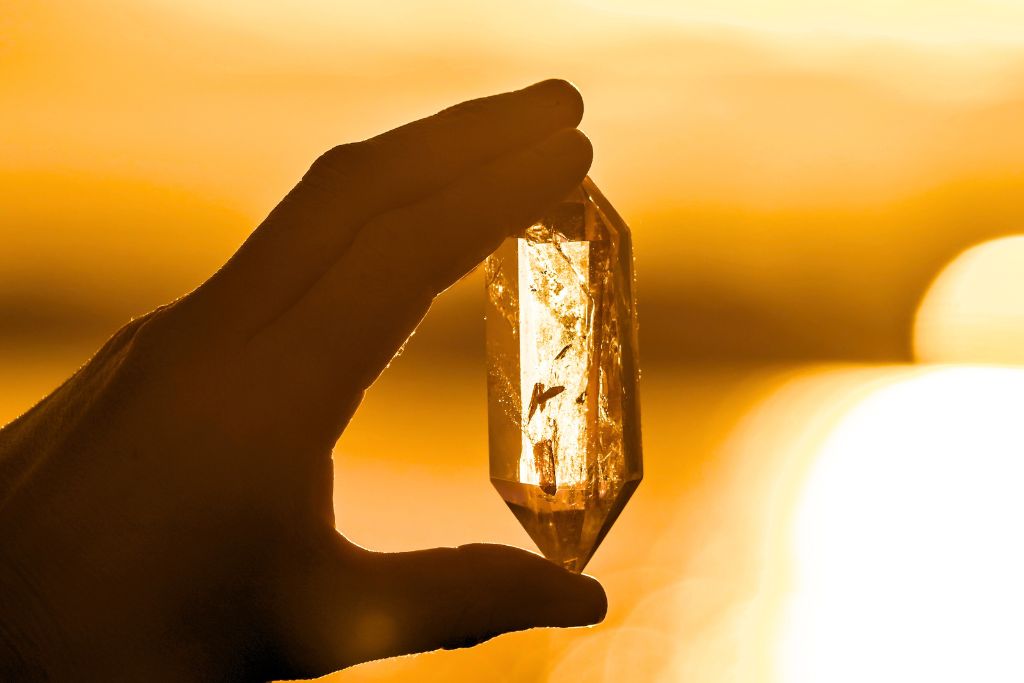 a person holding a small chunk of Quartz charging from the sun