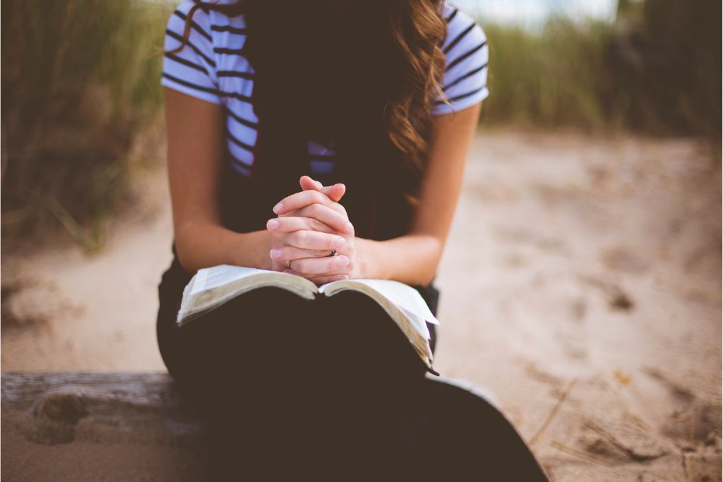 woman praying by the beach