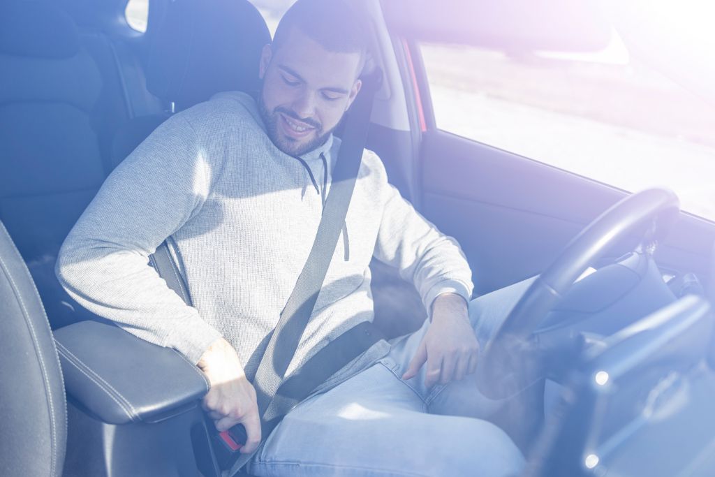 A man is fastening his seatbelt