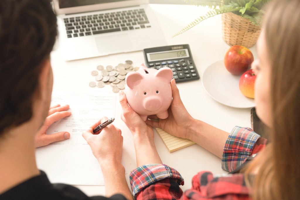 A woman is holding a piggy bank