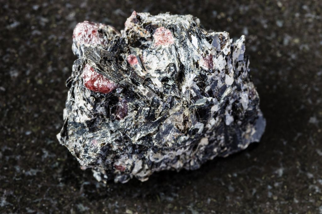 A biotite with red garnet on a black granite