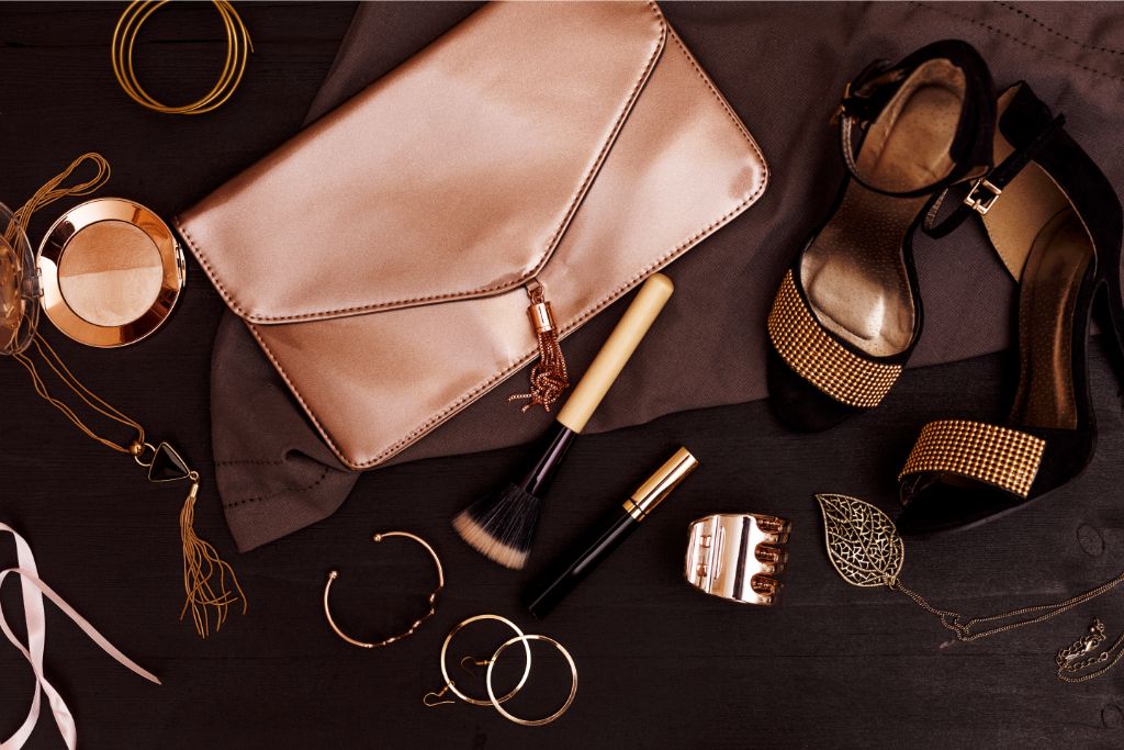 Brown accessories and brown makeup are arranged in a flatlay.