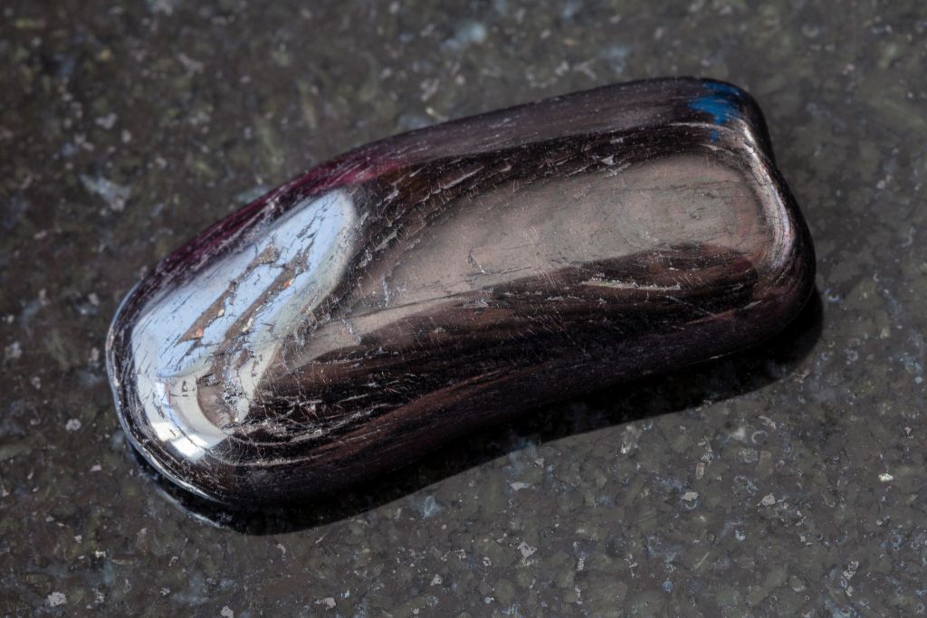 A Hypersthene crystal on a black granite