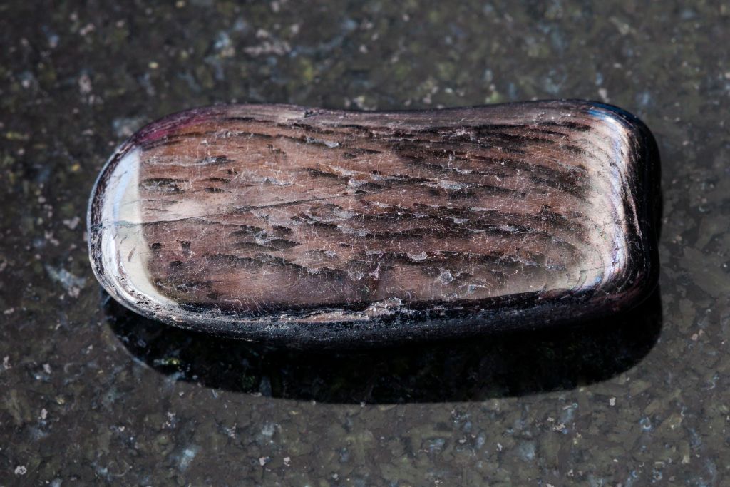 A Hypersthene crystal on a black granite