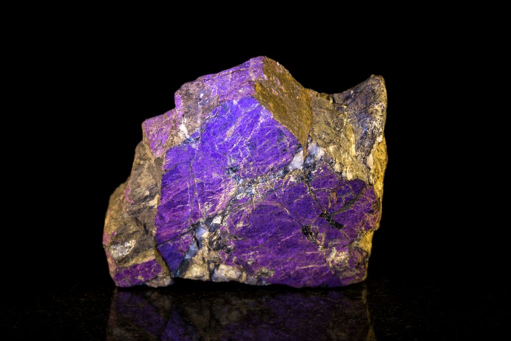 A Purpurite crystal on a black reflective background