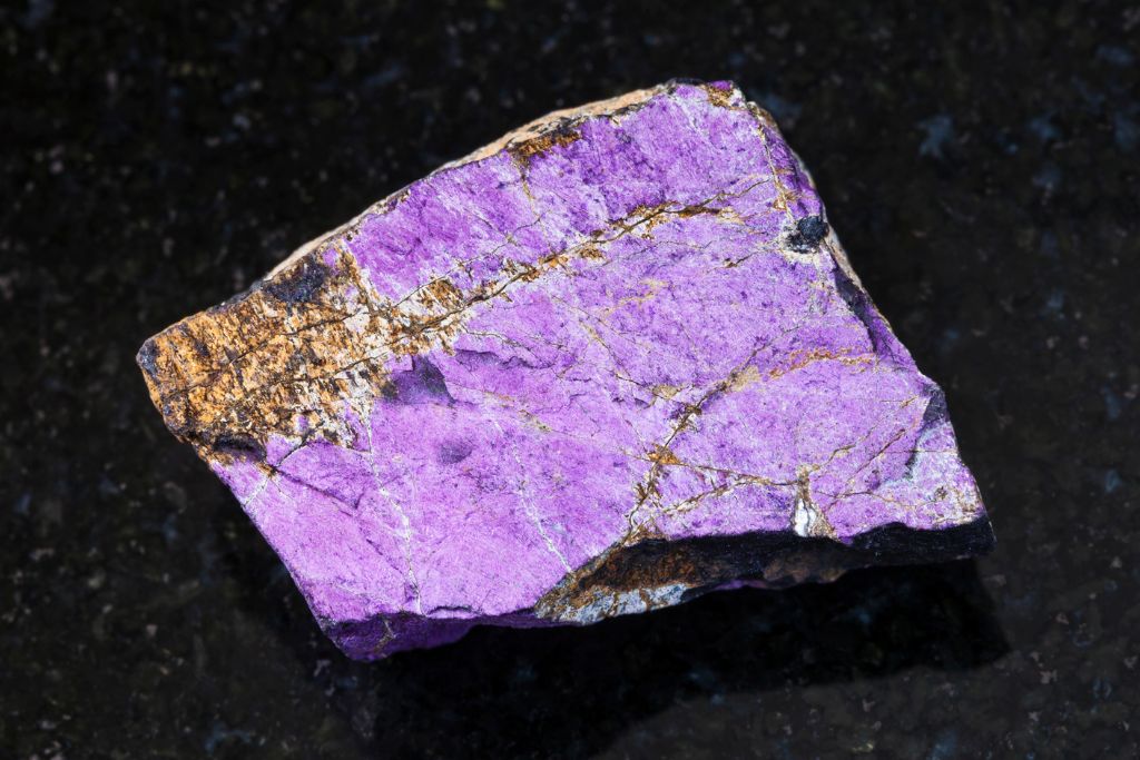 A Purpurite crystal on a black granite