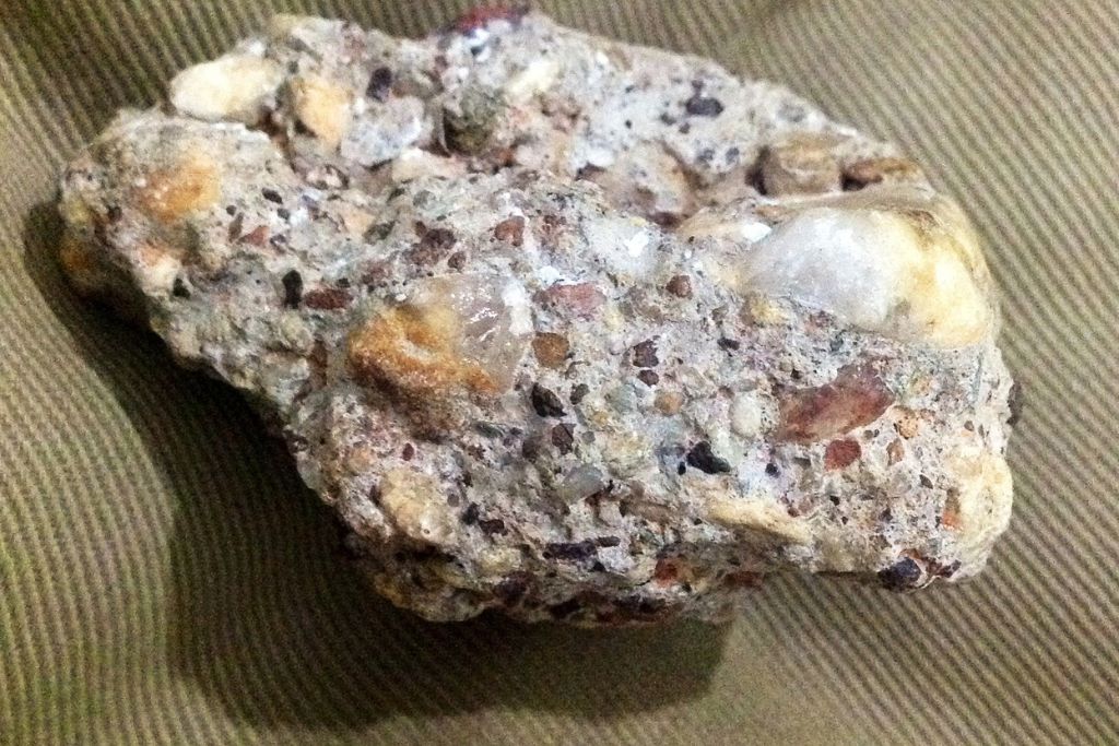 A Raw Conglomerate Stone Aka Pudding Stone on a golden cloth