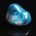 A Shattuckite crystal on a black reflective background