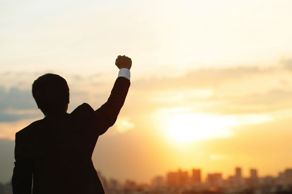 silhouette of a man fist close upward on a city background