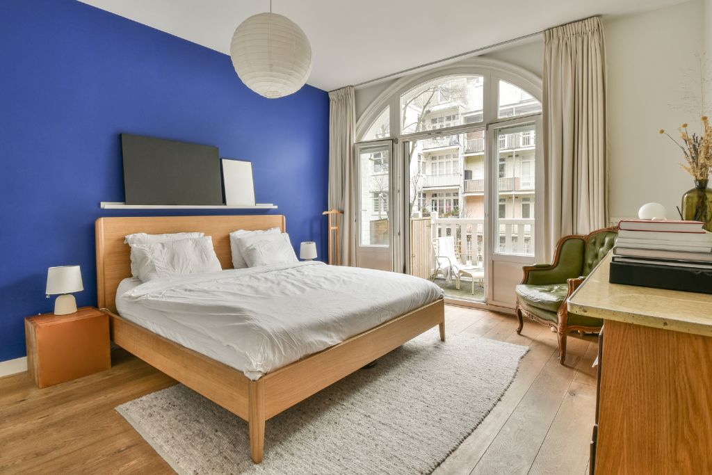 a bedroom with a bed and a blue accent wall