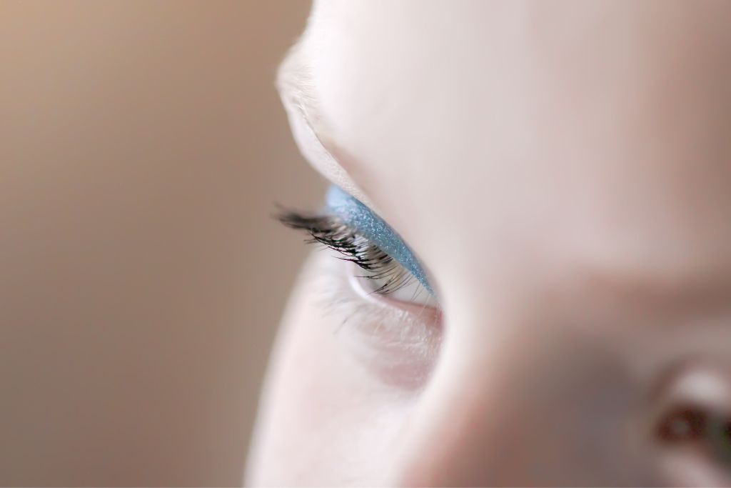 closeup of a woman with blue eyeshadow makeup
