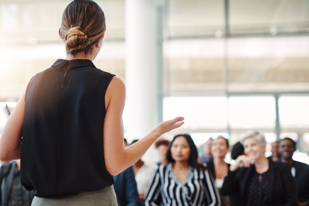 a woman speaking in front of people