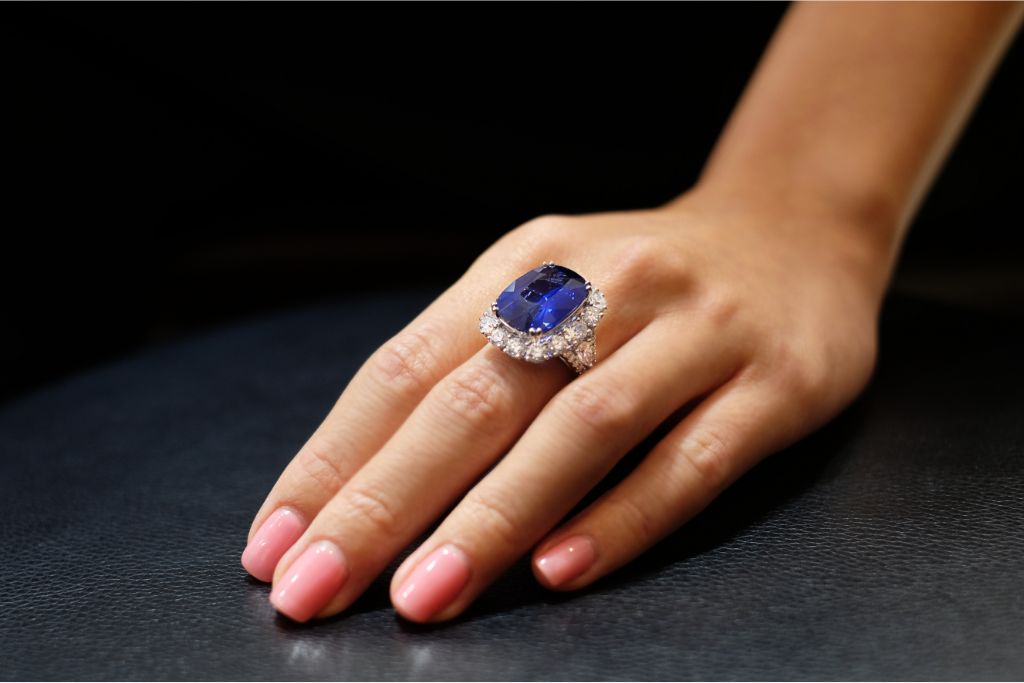 sapphire and diamond ring worn by a female model on her left index finger