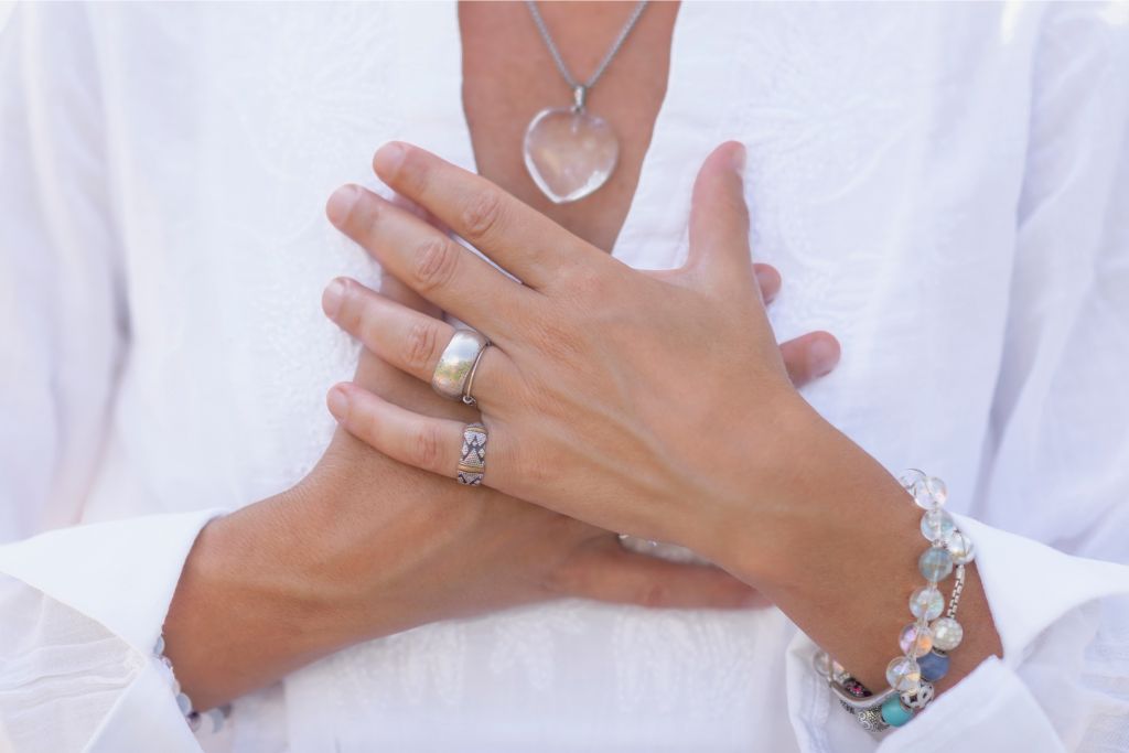 woman holding her hands to her chest in a mindful manner