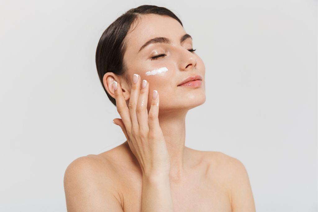 a woman applying a skincare product
