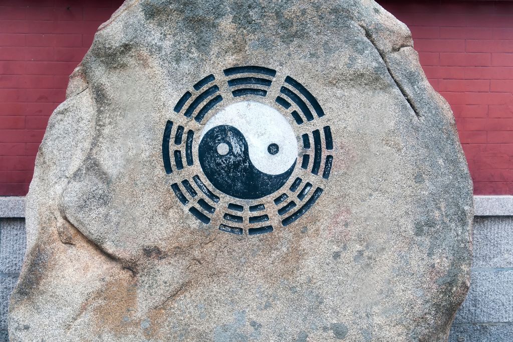 A yin yang symbol on a rock