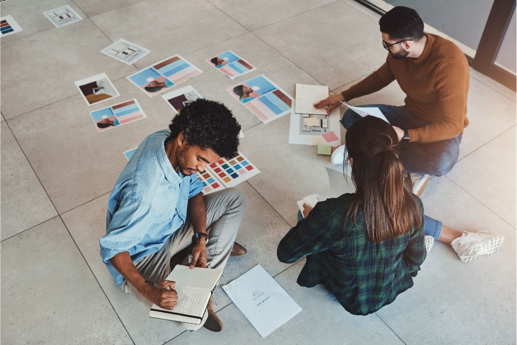 group of people brainstorming during a meeting while sitting on the floor