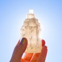 A person holding a satin spar crystal