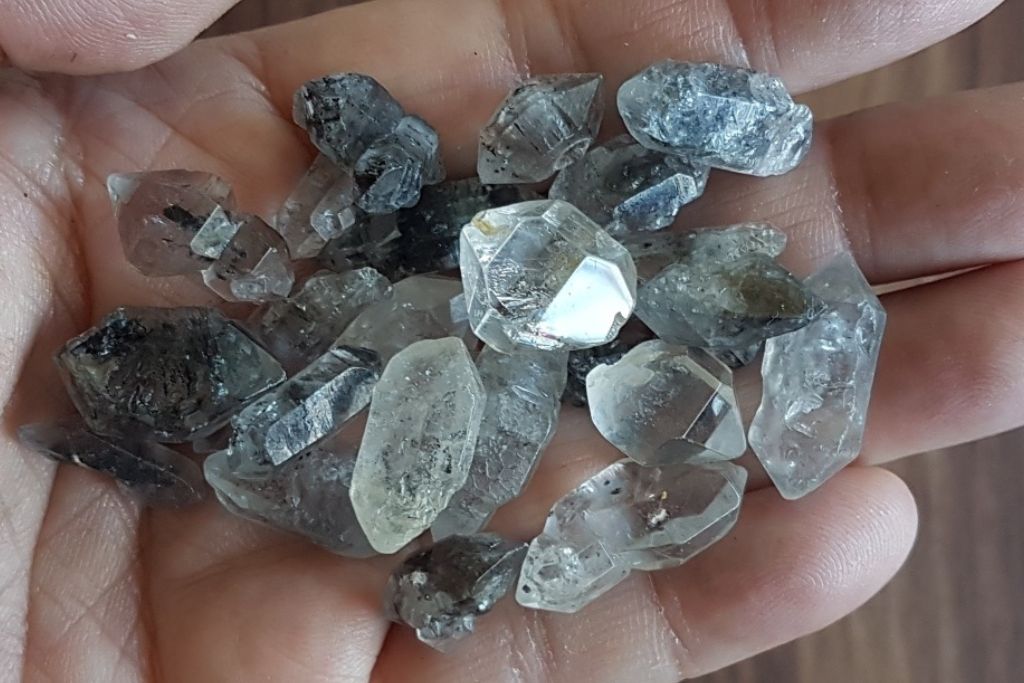 Small Tibetan Black Quartz crystals on a hand.
