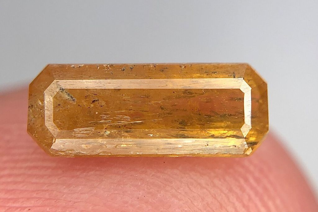 A Xenotime crystal on a finger. Source: Etsy | Gems4u2021