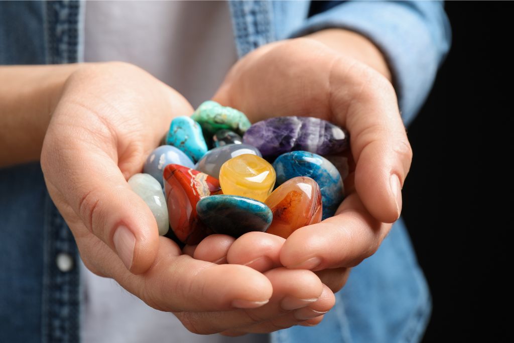 both hands holding different gemstones