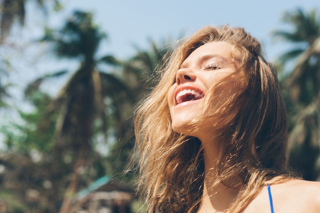 A happy woman basking under the sun.