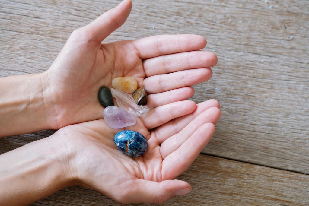 hands holding different crystals 