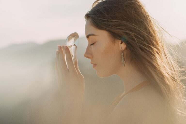 a woman holding a crystal in her hands