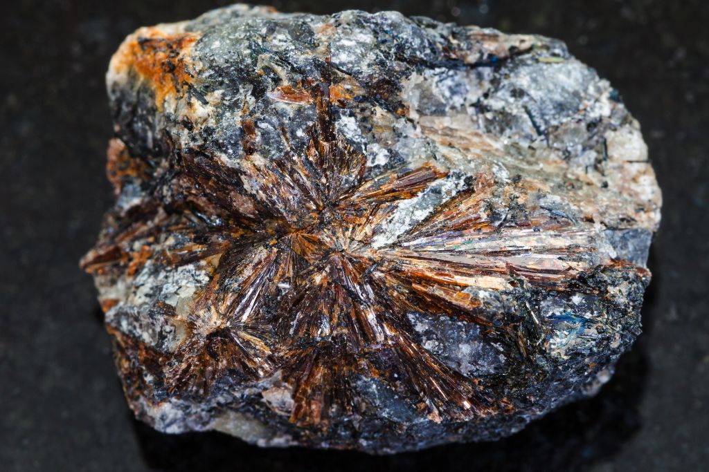 Lamprophyllite stone on a graphite background