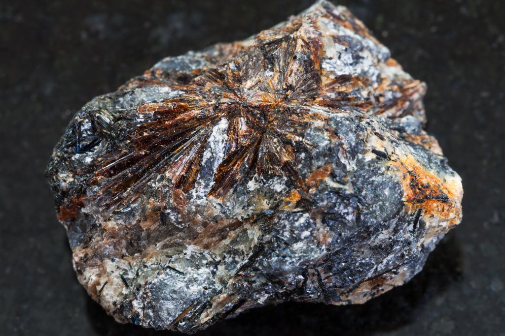 Lamprophyllite crystal on a graphite background