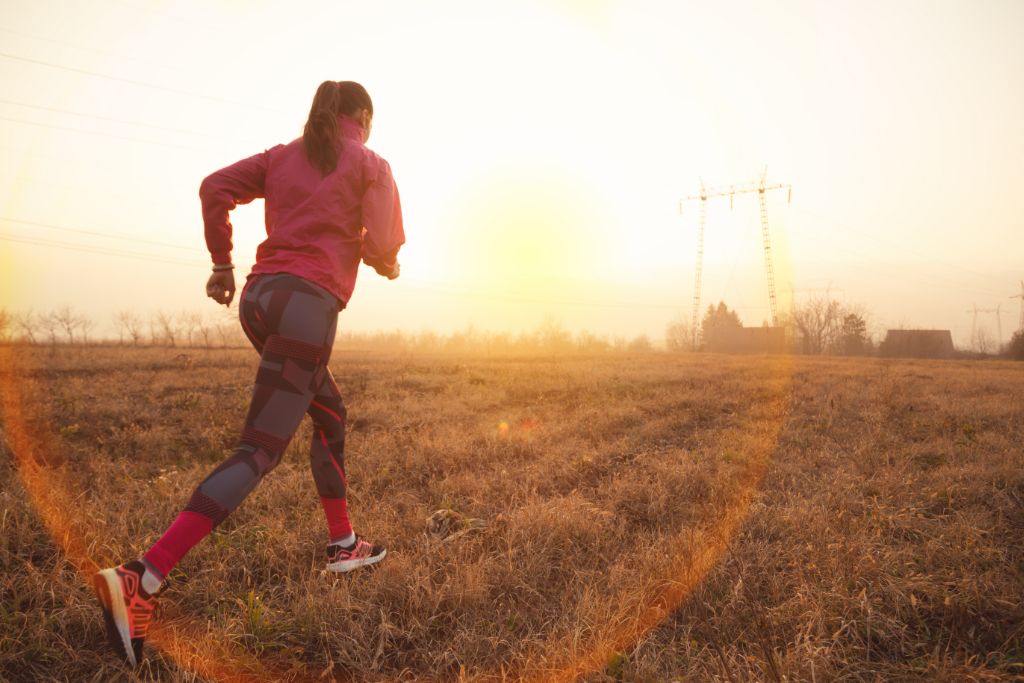 A motivated woman running in a field