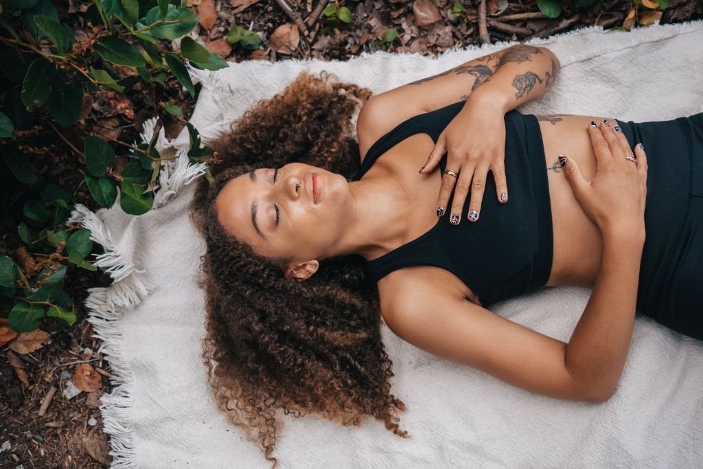 a girl laying on grass depicting earthly grounding