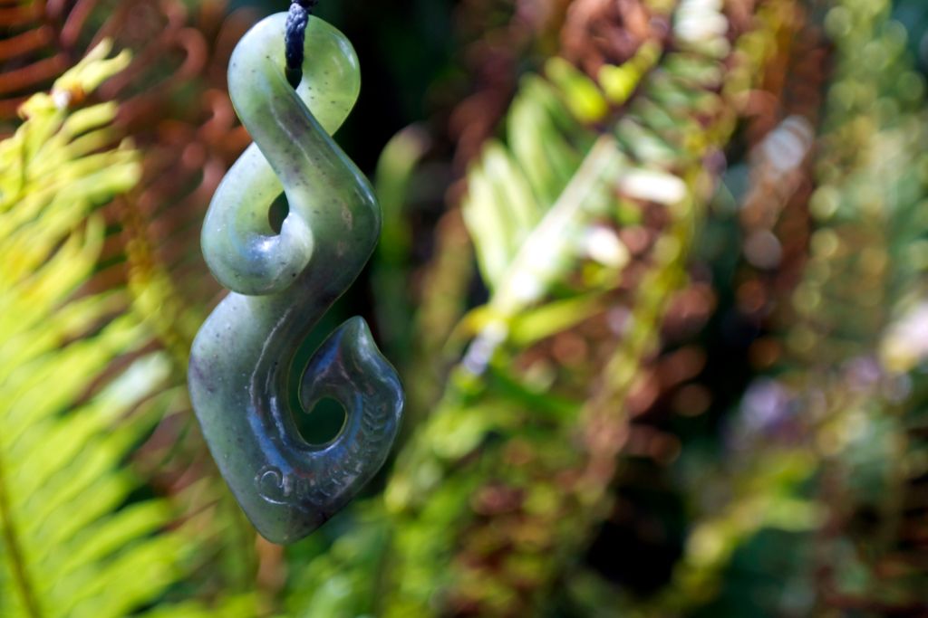 pounamu necklace with fern and tree background
