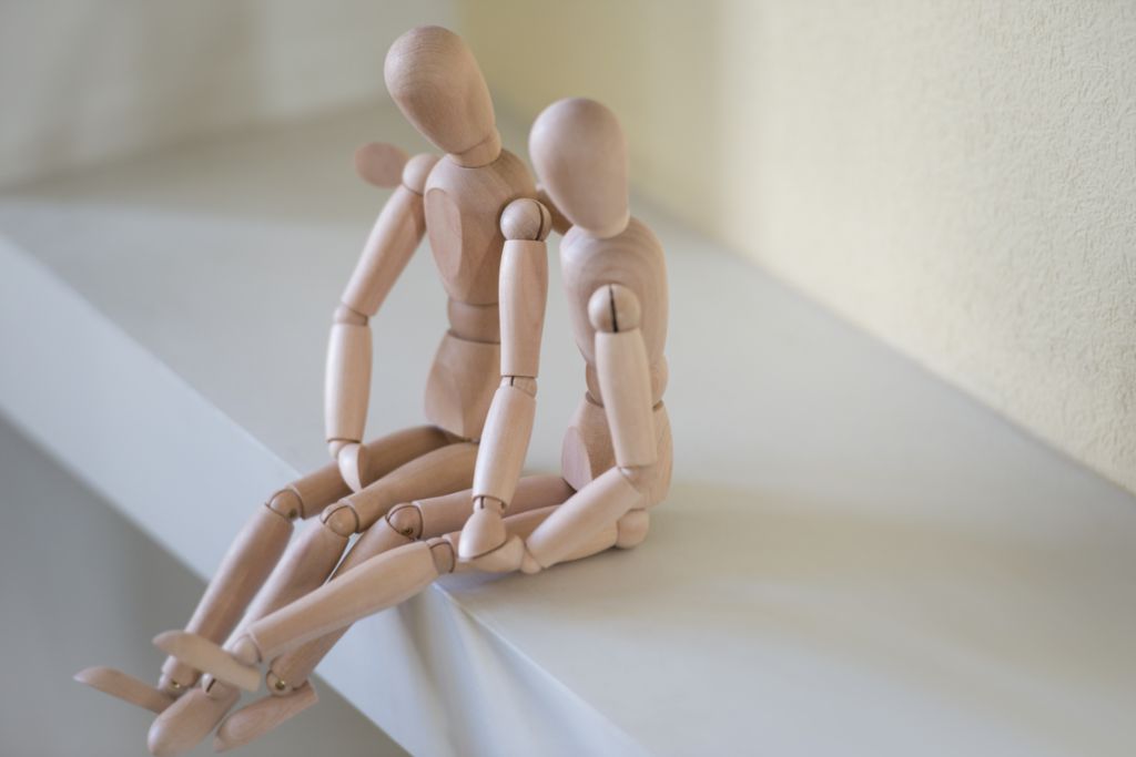 wooden figures sitting on a stair case