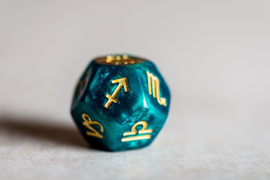 dice with a sagittarius symbol on a light surface